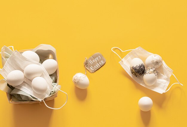 Safety masks and eggs flat lay. Happy Easter during the coronavirus pandemic.