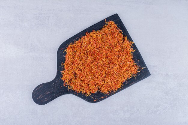 Saffron seeds on a black wooden platter . High quality photo