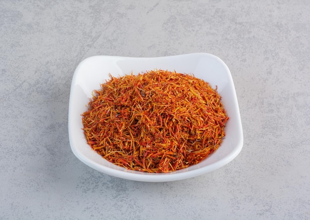 Saffron seeds in a white ceramic bowl. 