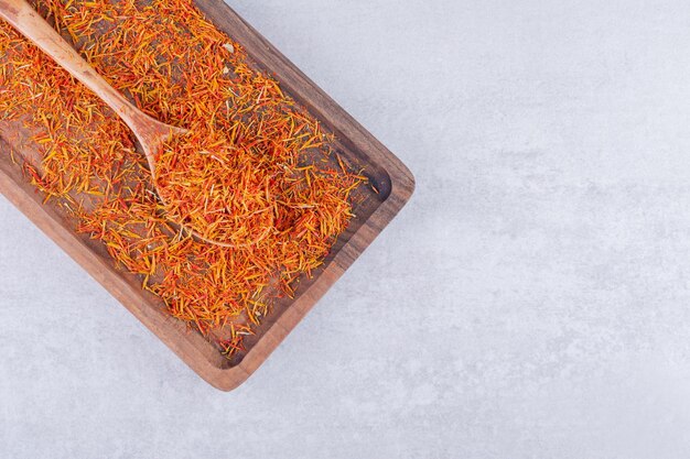 Saffron seeds on a wooden platter on concrete background. High quality photo