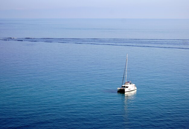 Sailing yacht on a tranquil ocean in Tropea