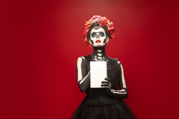 Saint death or Sugar skull with bright make-up on red