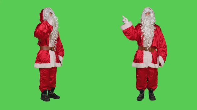 Foto gratuita personaggio di saint nick che esprime rifiuto e rifiuto, senza mostrare alcun simbolo sulla fotocamera. babbo natale si sente scontento e deluso, fa segno di disaccordo e delusione sullo schermo verde.