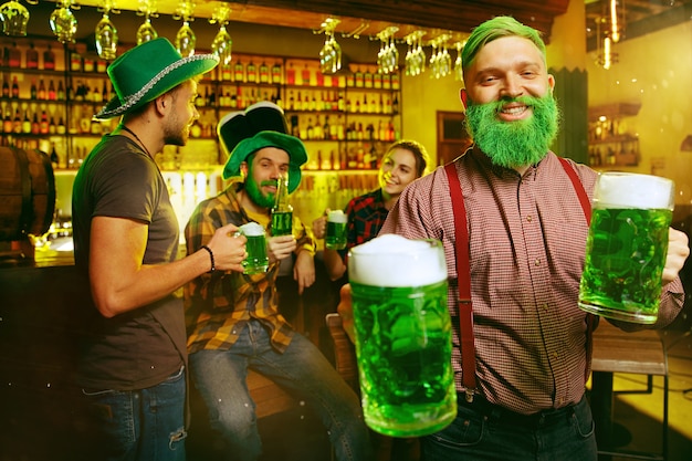 성 패트릭의 날 파티. 행복한 친구들이 축하하고 녹색 맥주를 마시고 있습니다.