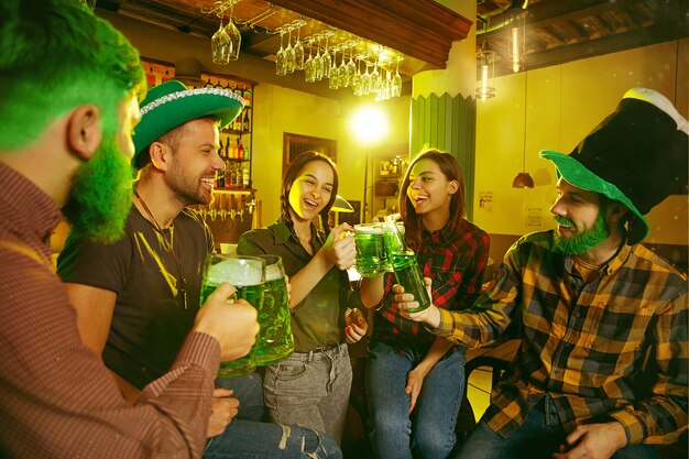 День Святого Патрика. Счастливые друзья празднуют и пьют зеленое пиво.