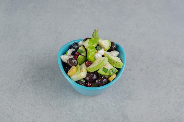 みじん切りの野菜と果物を混ぜた青いカップのサラダ。
