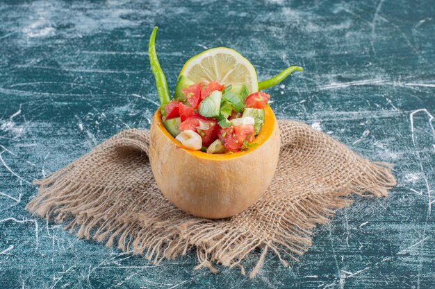 Salad in a carved pumkin with mixed ingredients. 