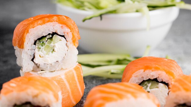 Salad and fresh sushi rolls close-up