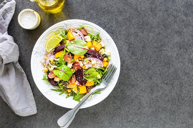 Free photo salad of fresh vegetables with beetroot arugula and red onion top view