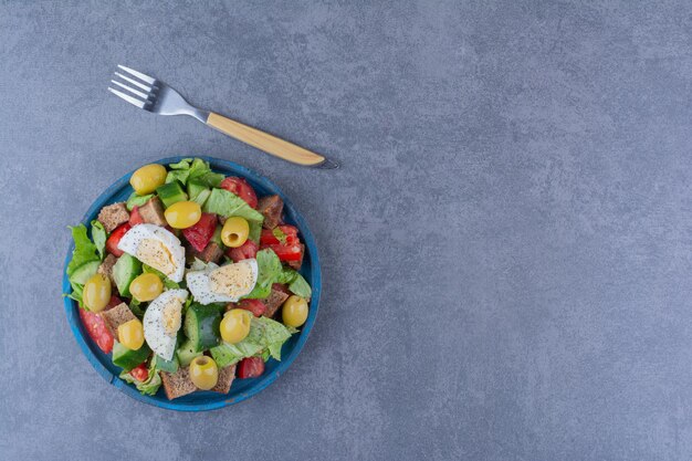 Salad mix with breakfast ingredients on marble surface