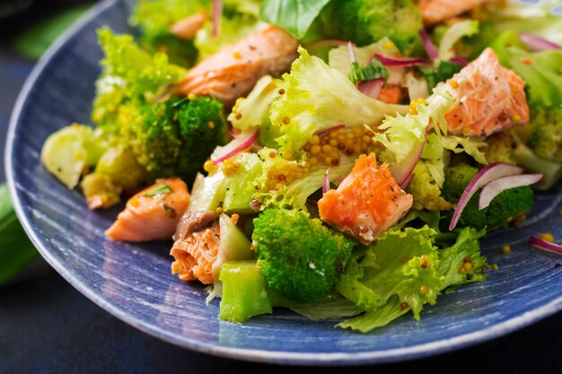 Salad of stewed fish salmon, broccoli, lettuce and dressing. Fish menu. Dietary menu. Seafood - salmon.