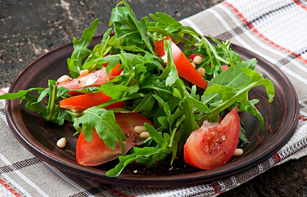 Salad with arugula, tomatoes and pine nuts