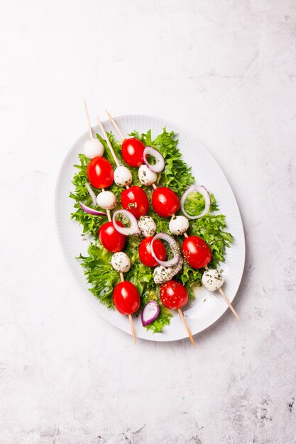 Salad with cheese and tomato skewers