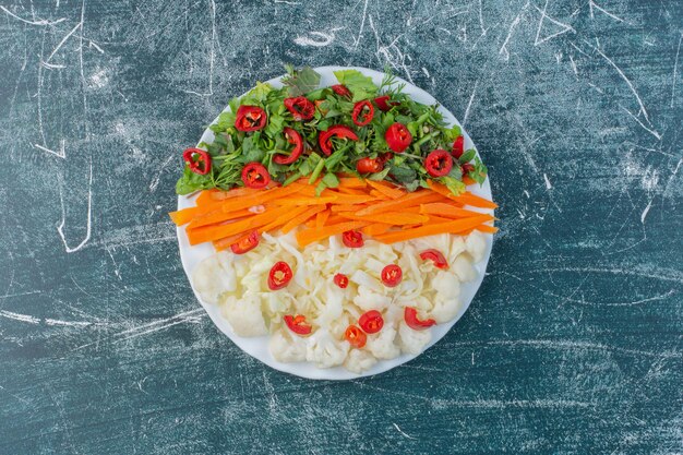 Salad with chopped green herbs and red chili peppers. 