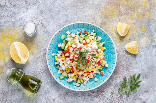 Salad with crab sticks, eggs, corn and cucumber.