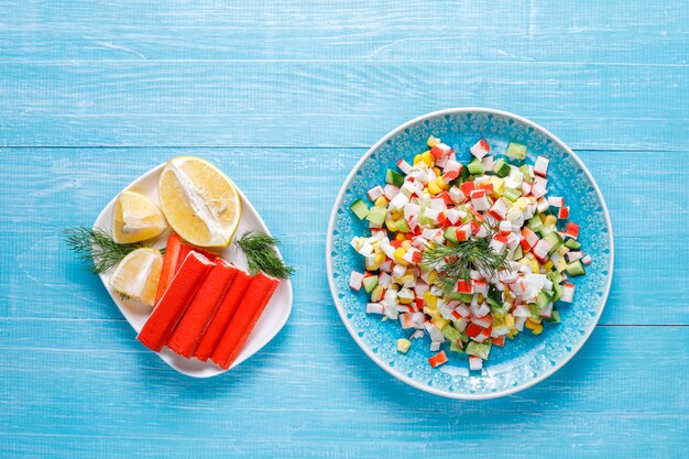 Salad with crab sticks, eggs, corn and cucumber.