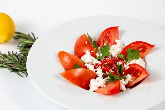Salad with fresh tomatoes greens and white cheese