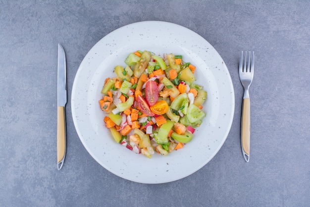 세라믹 접시에 녹색 야채와 방울토마토를 곁들인 샐러드