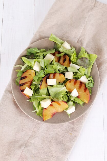 Salad with grilled peaches, arugula and mozzarella cheese