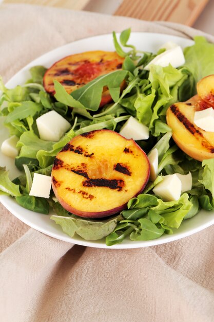 Salad with grilled peaches, arugula and mozzarella cheese