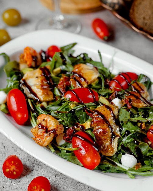 salad with grilled shrimps and tomatoes on table