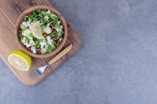 Salad with herbs, fruits and vegetables in a platter