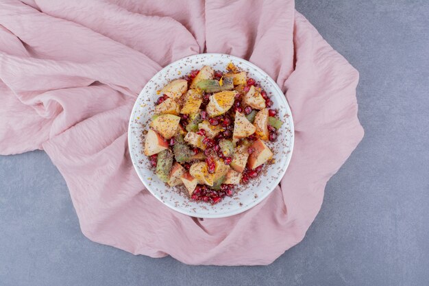 Salad with seasonal fruits and spices on concrete surface