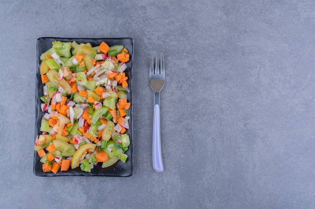 Салат с сезонными зеленью и овощами на блюде