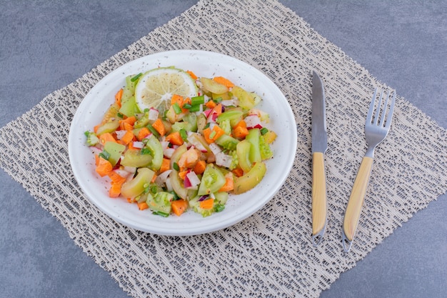 Салат с сезонными зеленью и овощами на блюде