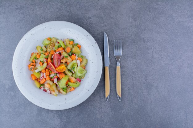 Salad with seasonal herbs and vegetables in a platter