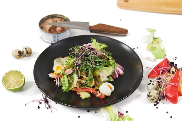 Salad with vegetables and fish in beautiful plate