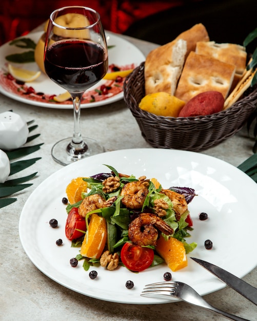 Salad with walnuts, tomatoes, oranges and shrimps