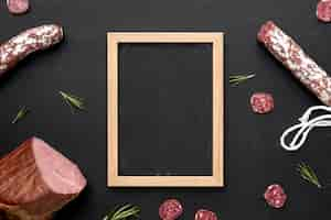 Free photo salami and fillet meat with frame on desk