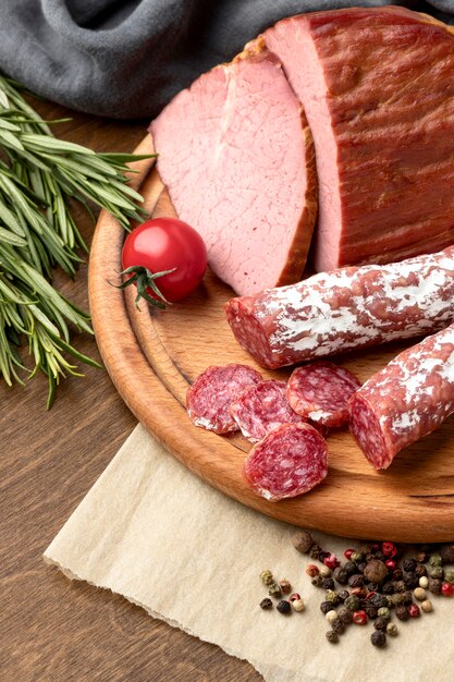 Salami and fillet meat on wooden board close-up