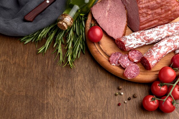 Salami and fillet meat on wooden board on desk