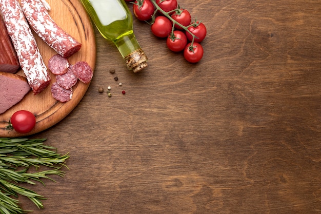 Salami and fillet meat on wooden board with copy-space