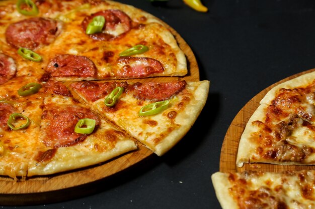 Salami pizza topped with fresh pepper slices close-up view