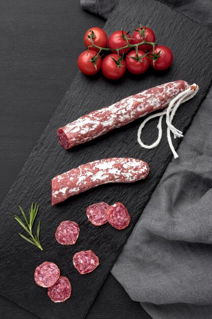 Salami and tomatoes on desk