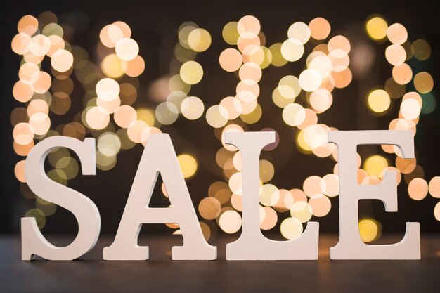 Sale inscription from wooden letters with bokeh 