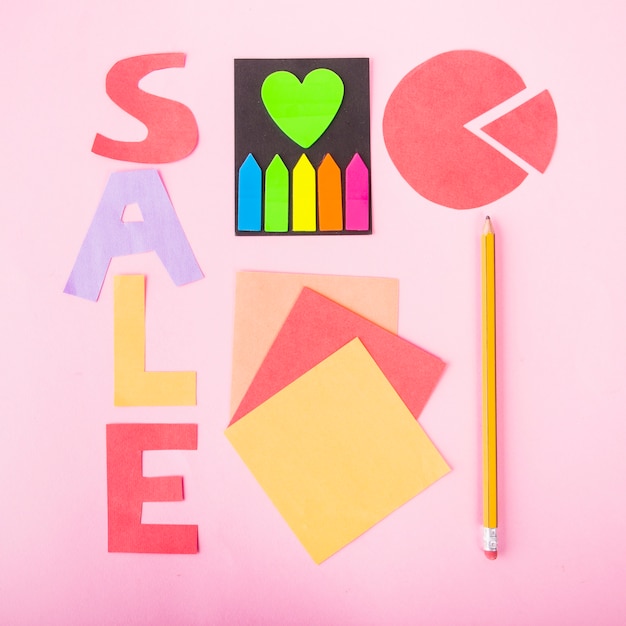 Sale lettering of paper on pink background