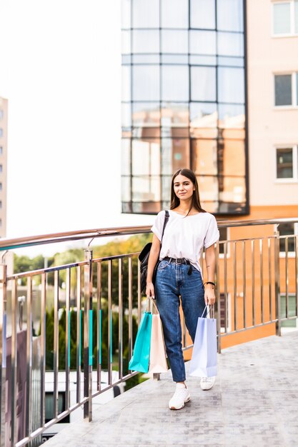 Sale, shopping, tourism and happy people concept - beautiful woman with shopping bags in the ctiy