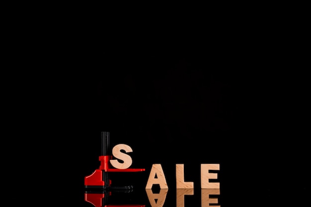Foto gratuita parola di vendita sul carrello elevatore con fondo nero