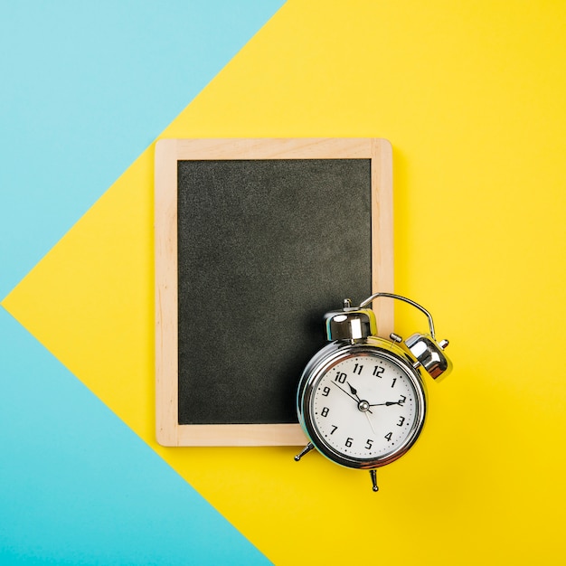 Sales concept with alarm clock on slate