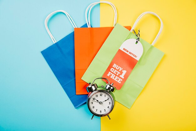 Sales concept with colorful bags and alarm