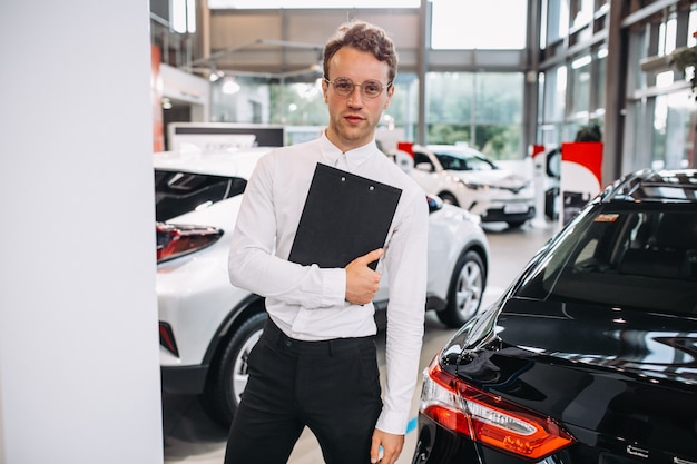 Free photo sales man in a car showroom