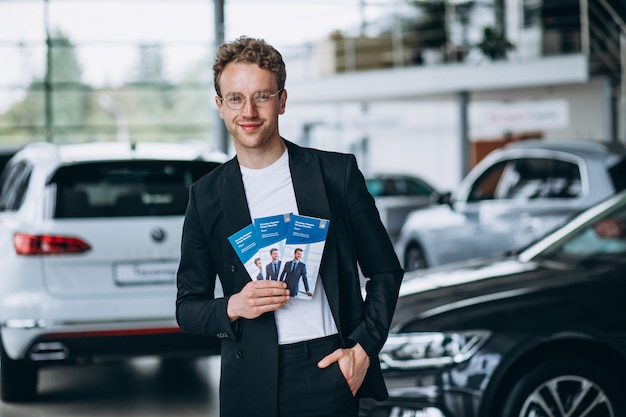 Free photo salesman at a car showroom with business flyers