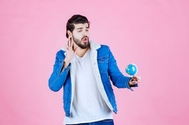 Salesman holding a mini globe and promoting the product