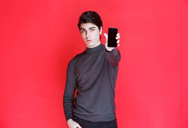 Salesman promoting and showing features of a new smartphone