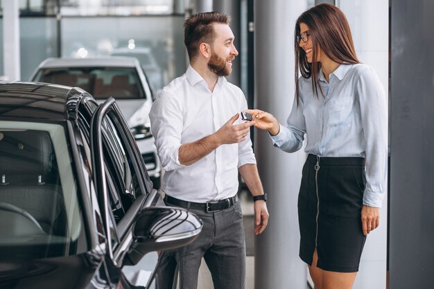 Salesman and woman looking for a car in a car showroom