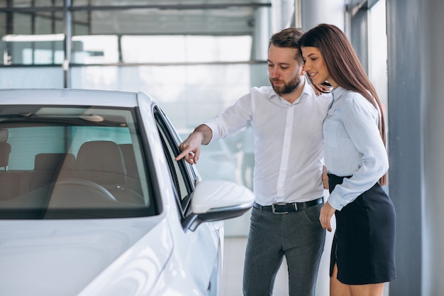 セールスマンと車のショールームで車を探している女性